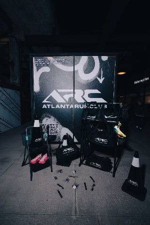 ARC branded equipment and chairs in a dark room with a large sign in the background.