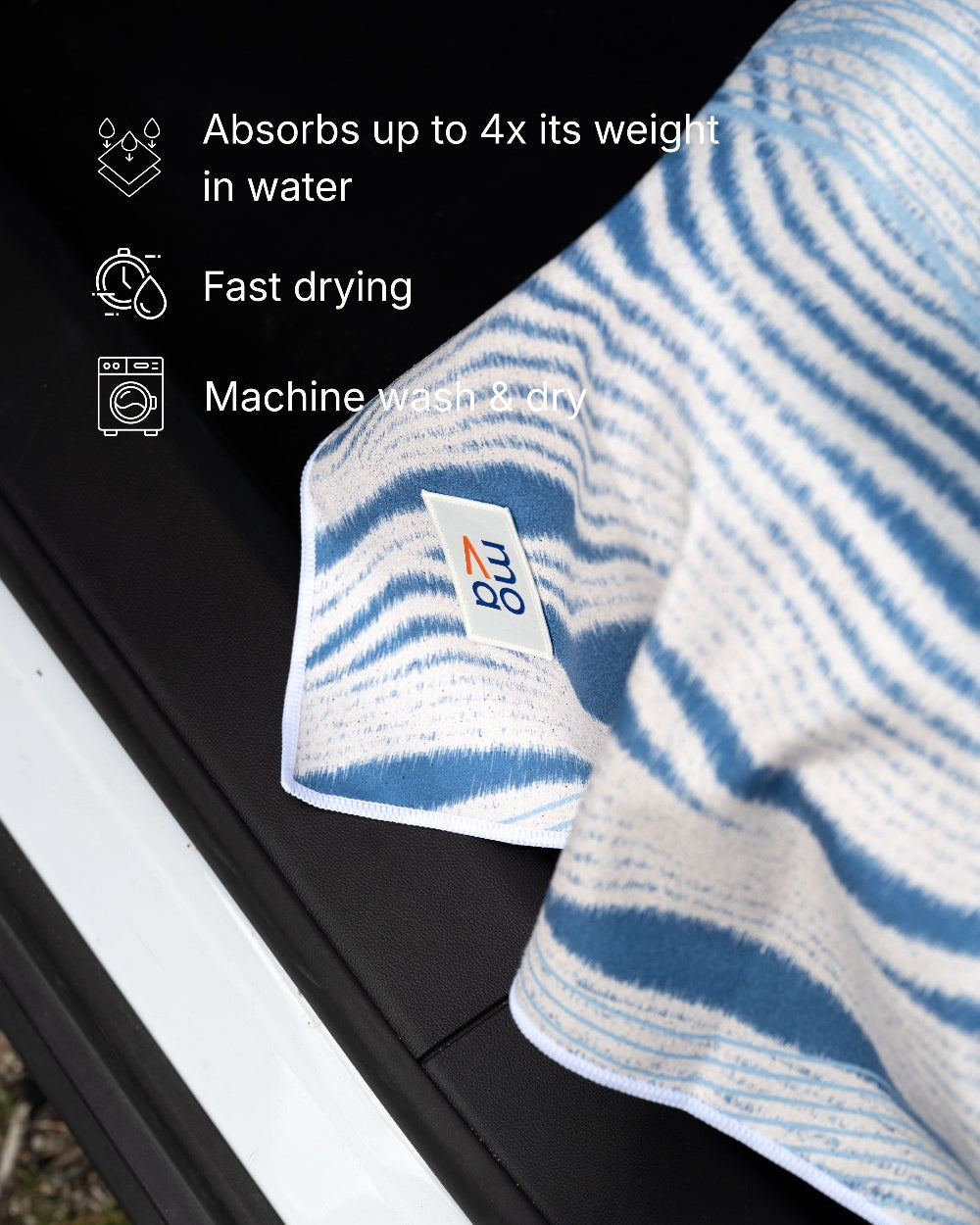 Striped towel with brand logo on a car window, featuring text about towel properties.