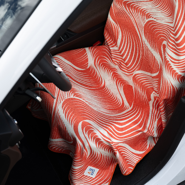 Red and white patterned fabric draped over a car window