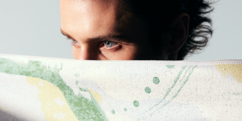 Man peeking over a surface with a visible brand logo