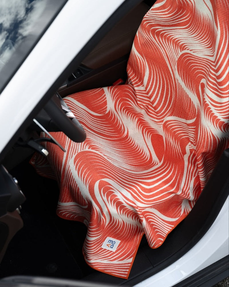 Red and white patterned car seat cover towel inside a vehicle